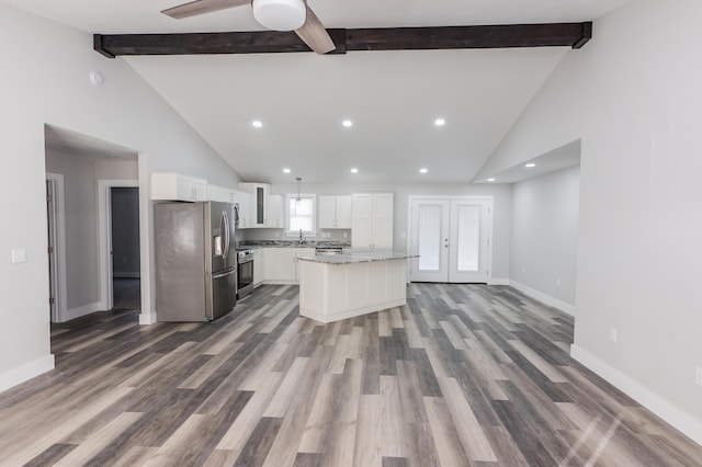 kitchen featuring beamed ceiling, a center island, white cabinets, and appliances with stainless steel finishes