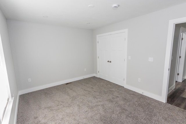 unfurnished bedroom featuring dark colored carpet