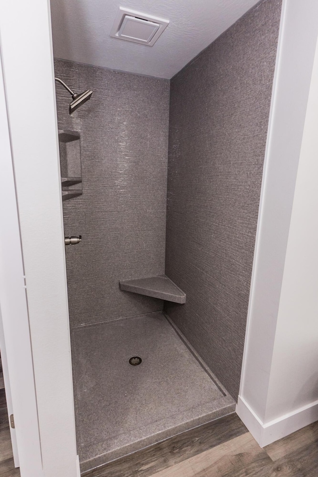 bathroom with wood-type flooring and walk in shower