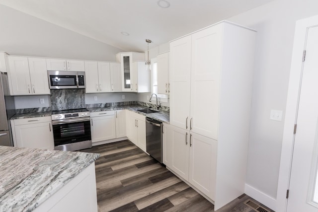 kitchen with decorative backsplash, stainless steel appliances, sink, decorative light fixtures, and white cabinetry