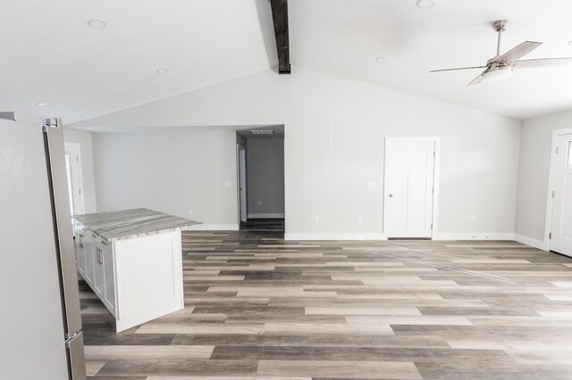 unfurnished living room with vaulted ceiling with beams, light hardwood / wood-style floors, and ceiling fan