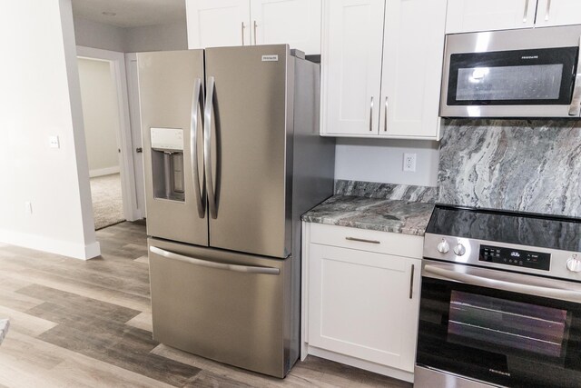 kitchen featuring stone counters, light hardwood / wood-style flooring, white cabinets, and stainless steel appliances