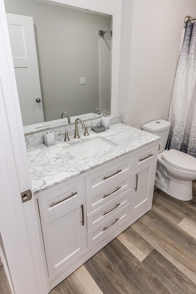 bathroom featuring hardwood / wood-style flooring, vanity, and toilet