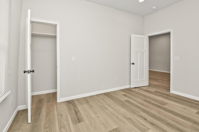 unfurnished bedroom featuring light hardwood / wood-style flooring and a closet