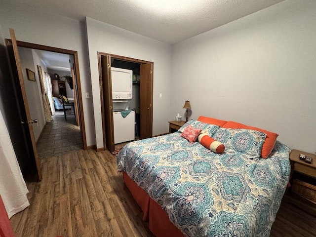 bedroom featuring stacked washer / dryer, a closet, and dark hardwood / wood-style flooring