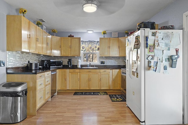 kitchen featuring light brown cabinets, light wood-type flooring, white refrigerator with ice dispenser, and sink