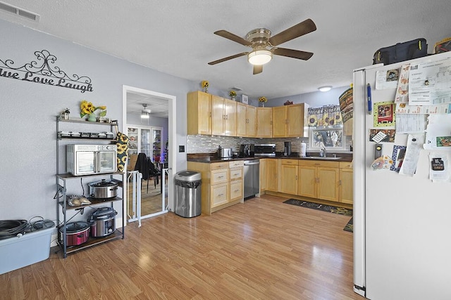 kitchen with dishwasher, light brown cabinets, light hardwood / wood-style flooring, tasteful backsplash, and white fridge