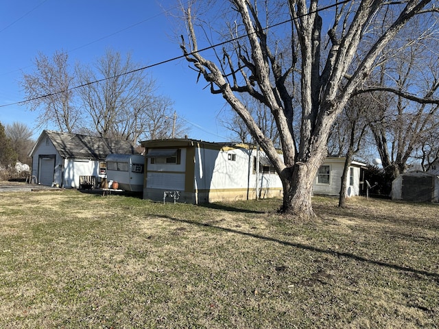 view of yard featuring a garage and an outbuilding