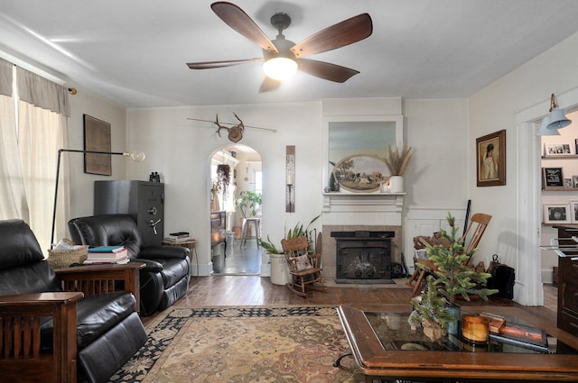 living room with a fireplace, ceiling fan, and hardwood / wood-style floors