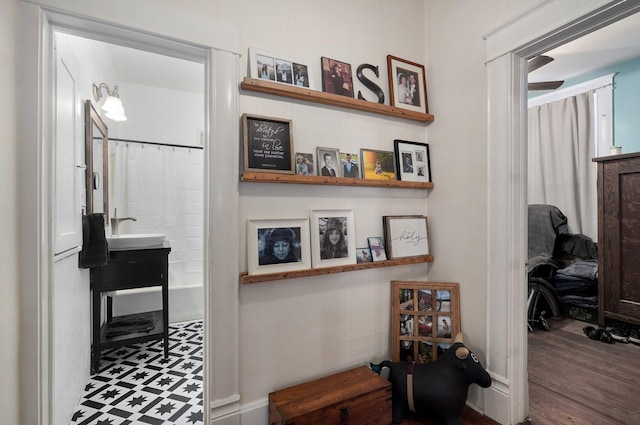 corridor with hardwood / wood-style flooring and sink