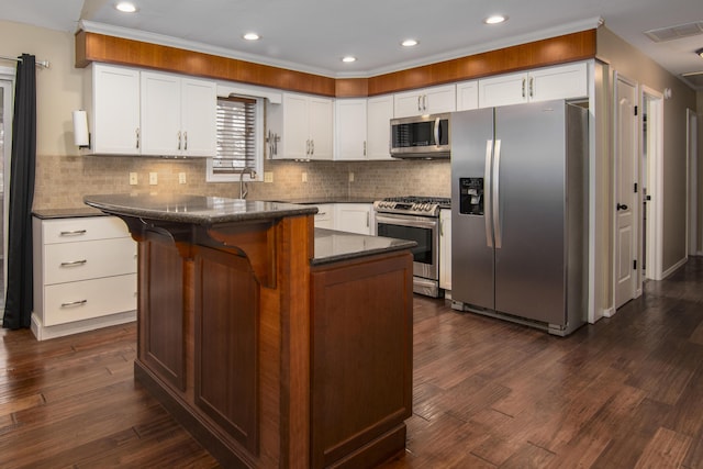 1012 W Monarch Dr, Nixa, MO 65714 - kitchen with appliances with stainless steel finishes, tasteful backsplash, white cabinets, recessed lighting, and dark wood-type flooring