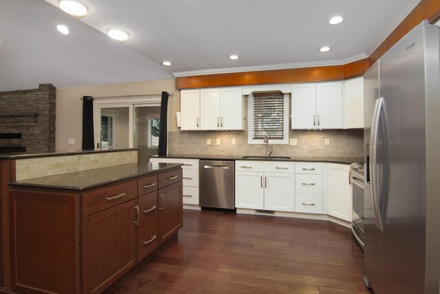 1012 W Monarch Dr, Nixa, MO 65714 - kitchen featuring appliances with stainless steel finishes, tasteful backsplash, white cabinetry, dark wood-style floors, and recessed lighting