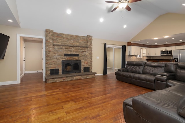1012 W Monarch Dr, Nixa, MO 65714 - living area with ceiling fan, a fireplace, wood finished floors, and high vaulted ceiling