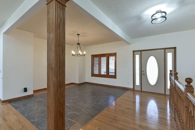 foyer entrance featuring beam ceiling and a chandelier