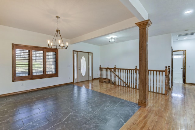 entrance foyer with decorative columns and a chandelier