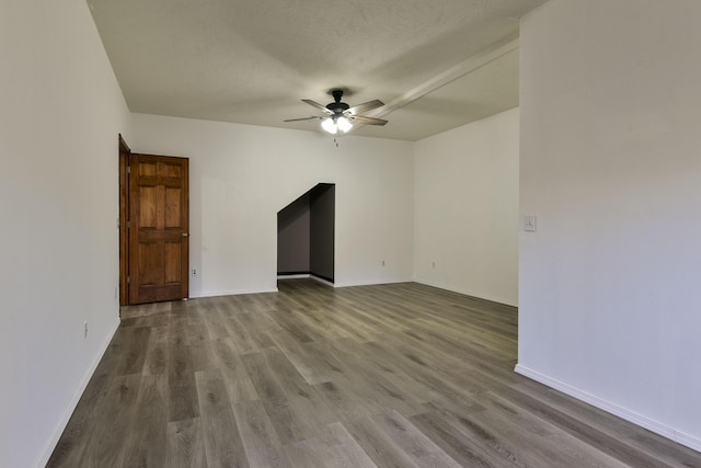 unfurnished room with ceiling fan, wood-type flooring, and a textured ceiling