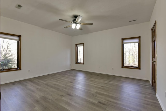 spare room featuring hardwood / wood-style floors, a wealth of natural light, and ceiling fan