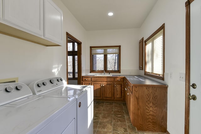 laundry area with cabinets, washer and clothes dryer, a healthy amount of sunlight, and sink