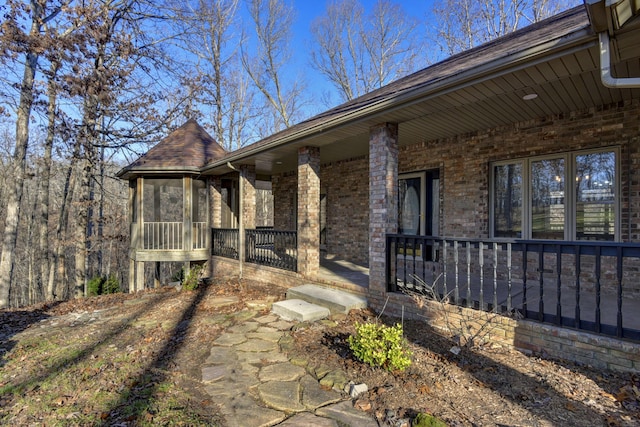 view of exterior entry featuring covered porch