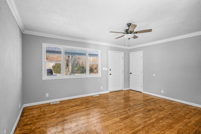 empty room featuring hardwood / wood-style floors, a textured ceiling, ornamental molding, and ceiling fan