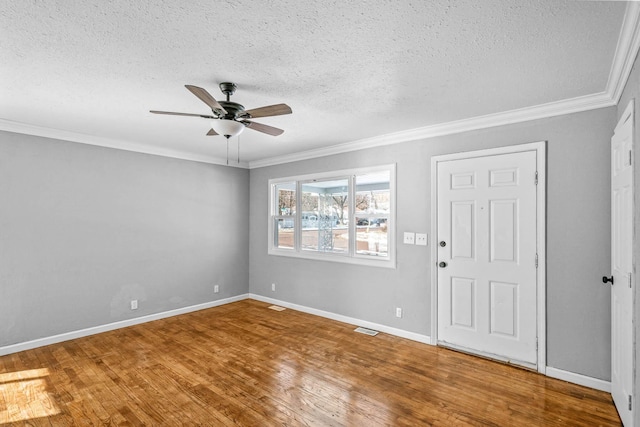 entryway featuring hardwood / wood-style floors, a textured ceiling, ceiling fan, and ornamental molding