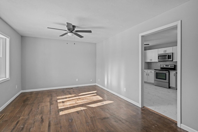 empty room with dark hardwood / wood-style flooring and ceiling fan