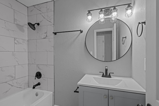 bathroom featuring tiled shower / bath combo and vanity