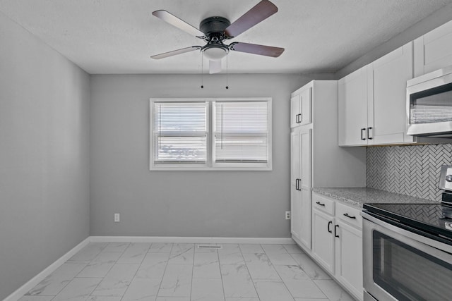 kitchen featuring stainless steel appliances, white cabinetry, ceiling fan, and backsplash