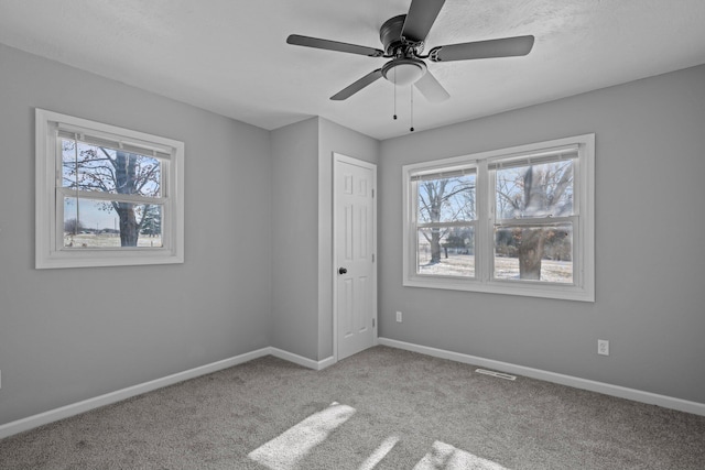 carpeted spare room with ceiling fan