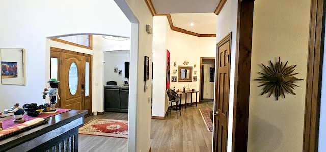 foyer entrance featuring crown molding and hardwood / wood-style floors