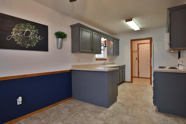 kitchen with gray cabinets, stove, and sink