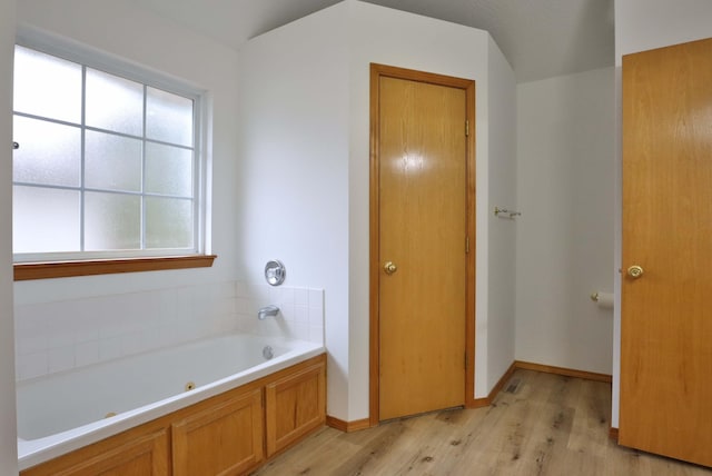 bathroom with hardwood / wood-style flooring and a bathtub