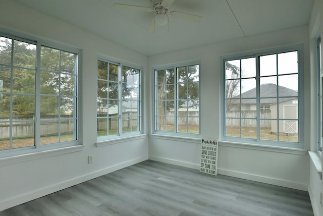 unfurnished sunroom featuring ceiling fan