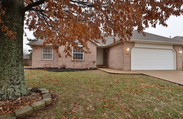 ranch-style house featuring a garage and a front lawn