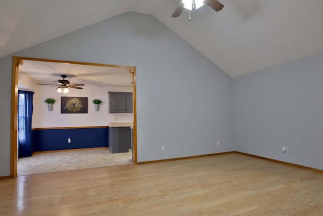 unfurnished living room featuring ceiling fan, vaulted ceiling, and light wood-type flooring