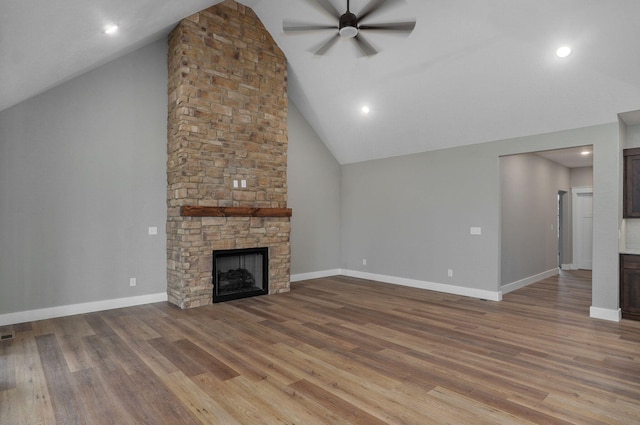 unfurnished living room with ceiling fan, a fireplace, high vaulted ceiling, and light hardwood / wood-style floors