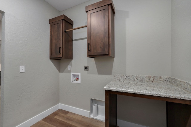 laundry area featuring hookup for an electric dryer, hookup for a washing machine, light hardwood / wood-style floors, and cabinets