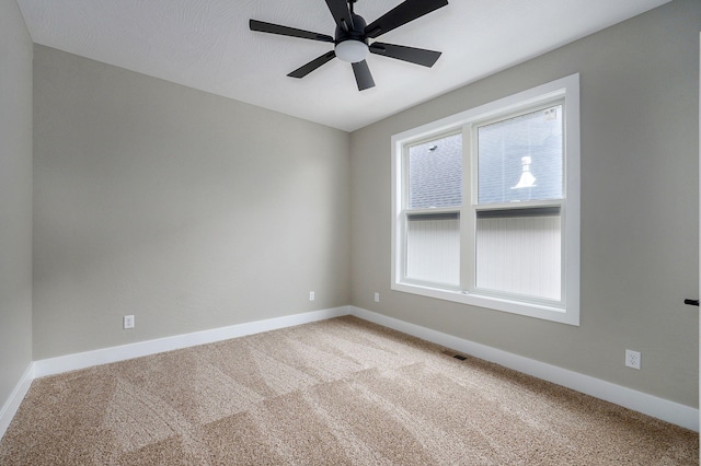 unfurnished room with carpet flooring, ceiling fan, and a wealth of natural light