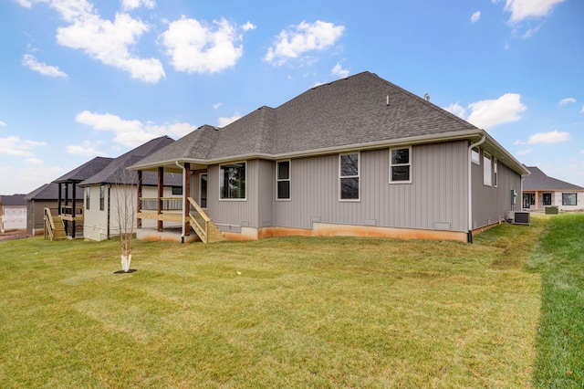 rear view of property with a yard and central AC