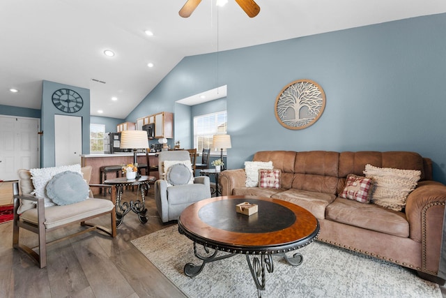 living room with light hardwood / wood-style floors, ceiling fan, and lofted ceiling