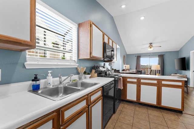 kitchen featuring lofted ceiling, black appliances, sink, ceiling fan, and light tile patterned floors