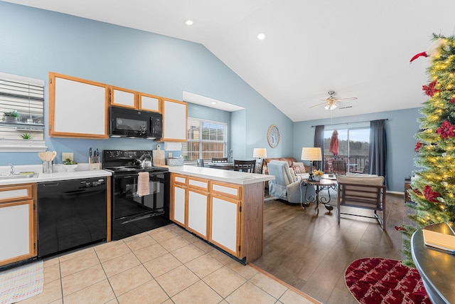 kitchen featuring white cabinetry, sink, ceiling fan, vaulted ceiling, and black appliances