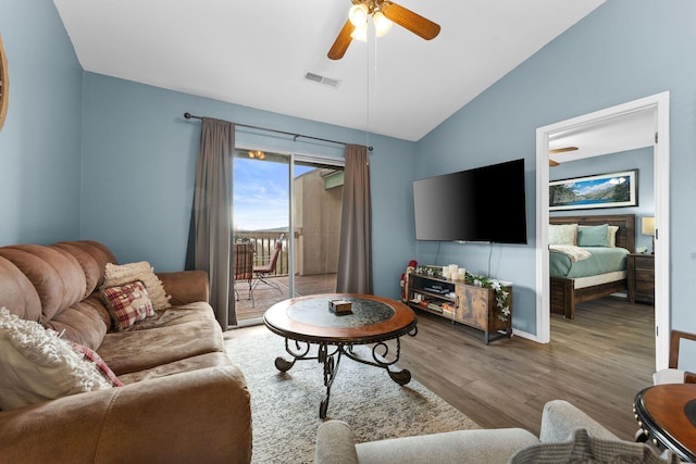 living room with ceiling fan, vaulted ceiling, and light hardwood / wood-style flooring