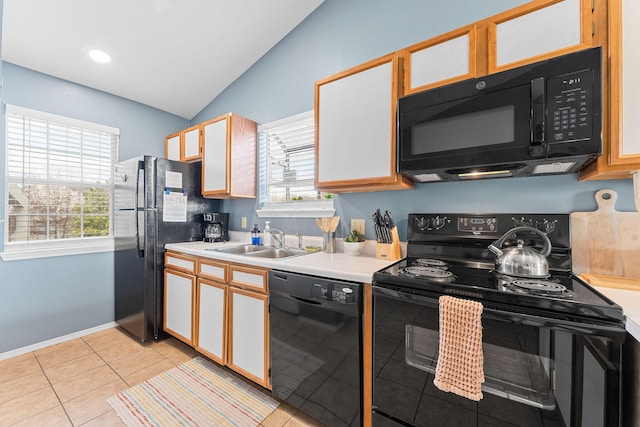 kitchen featuring sink, white cabinetry, lofted ceiling, and black appliances