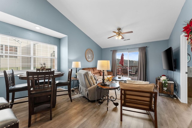 living room featuring ceiling fan, light hardwood / wood-style floors, and lofted ceiling