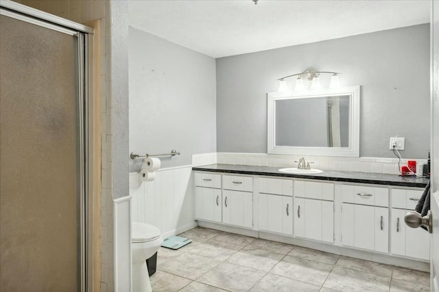 bathroom featuring vanity, toilet, and walk in shower