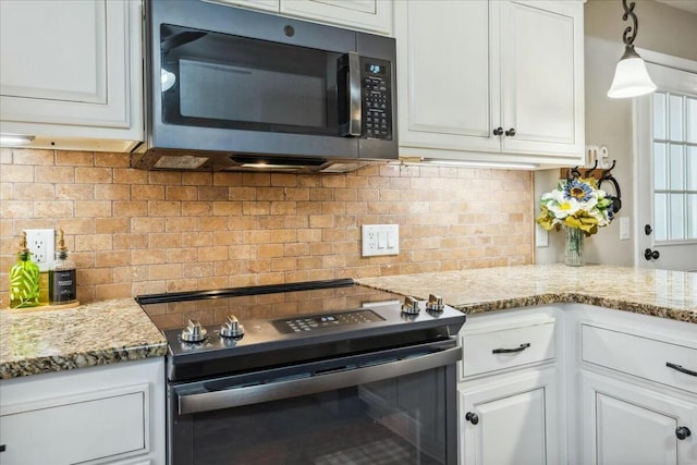 kitchen featuring white cabinets, light stone counters, stainless steel appliances, and tasteful backsplash