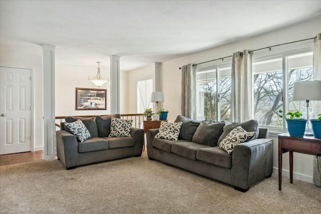 living room with carpet floors and decorative columns