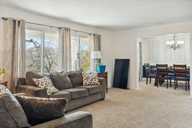 living room featuring light carpet and an inviting chandelier