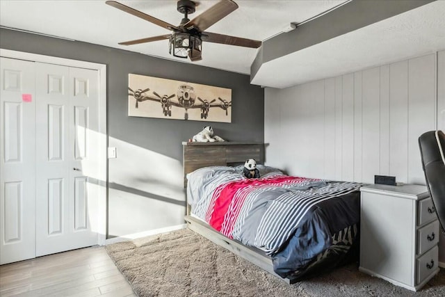 bedroom featuring ceiling fan, light wood-type flooring, and a closet